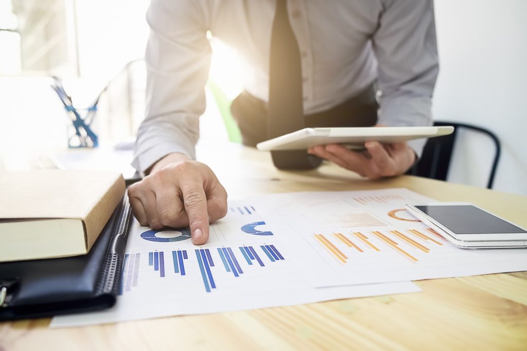 man pointing at two separate charts - What Does ROI Stand For: Arcane Marketing